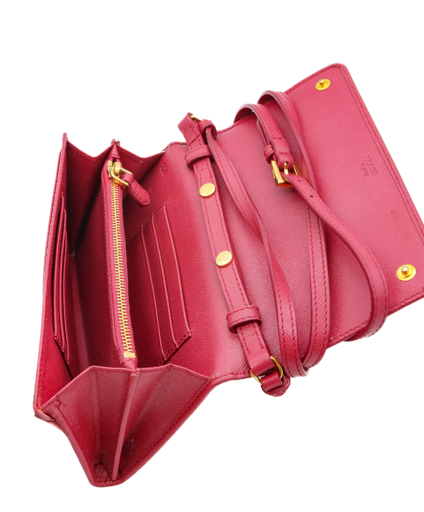 Pink Prada handbag with gold zippers and accents on a white background