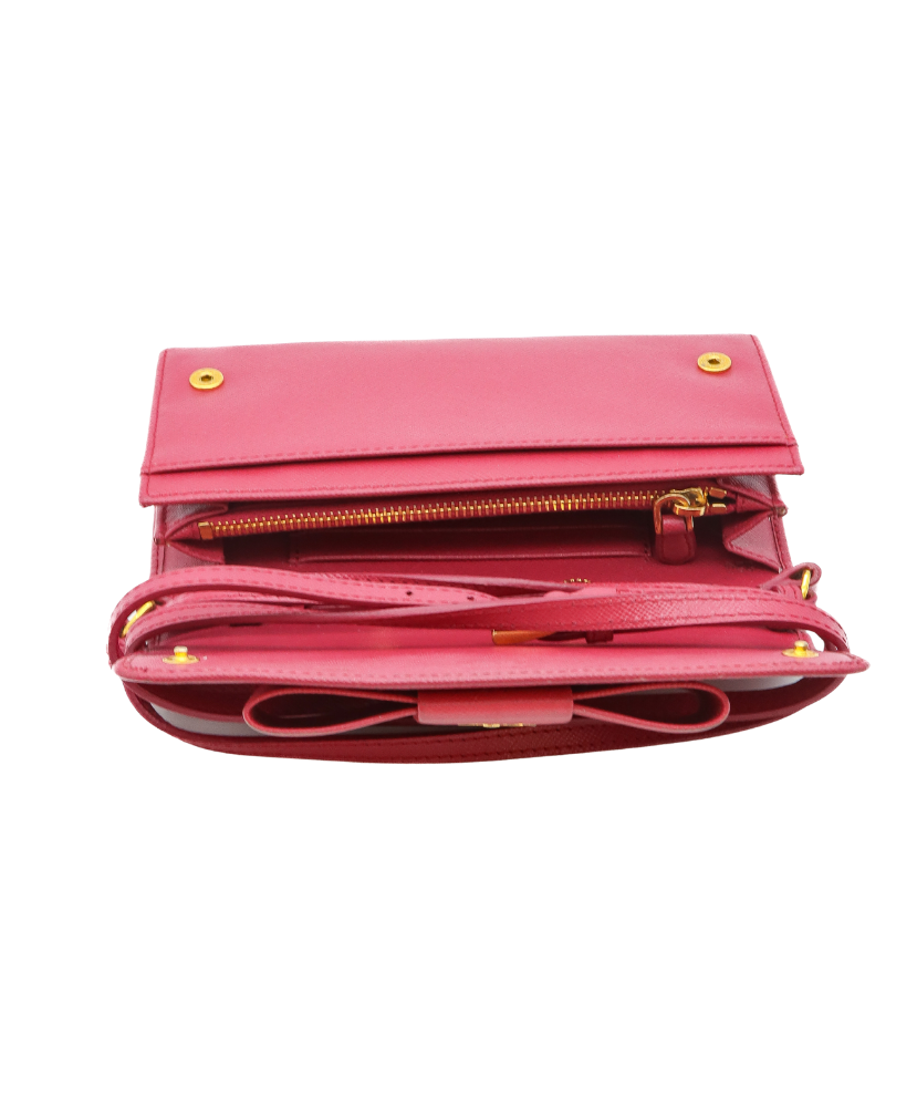 Pink Prada handbag with gold zippers on a white background