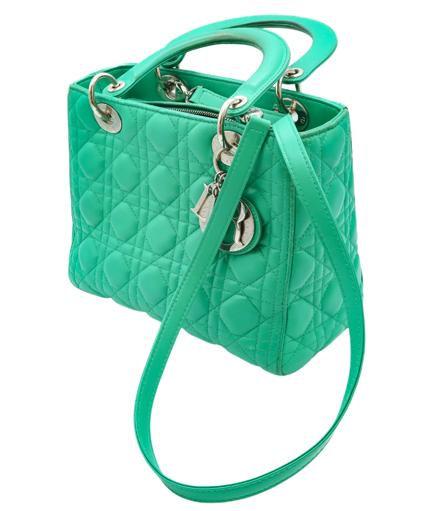 Green Dior quilted handbag with a strap on a white background