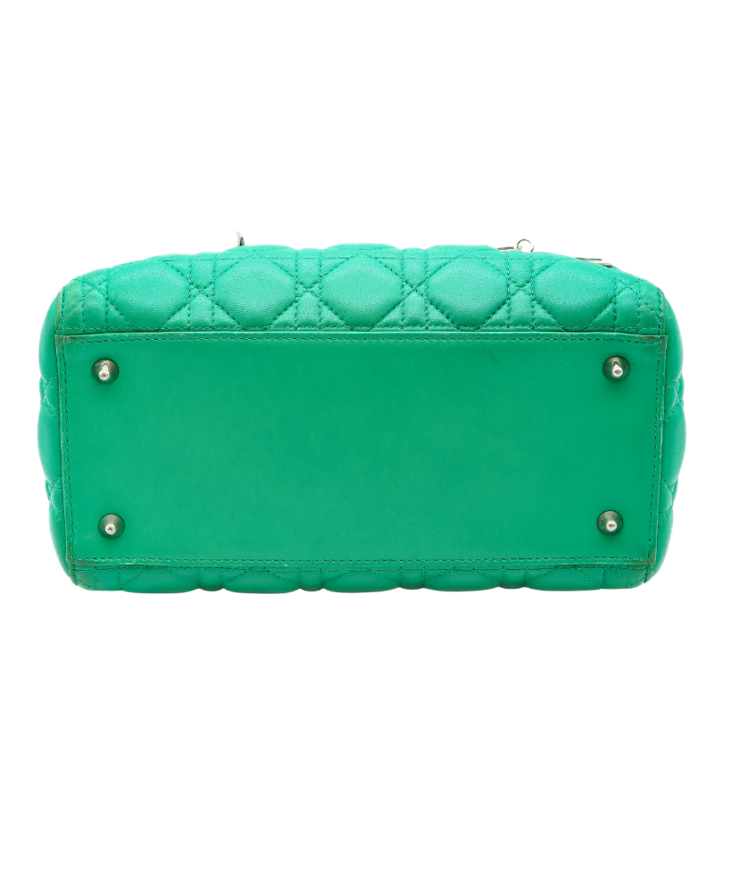 Green Dior quilted handbag with a strap on a white background