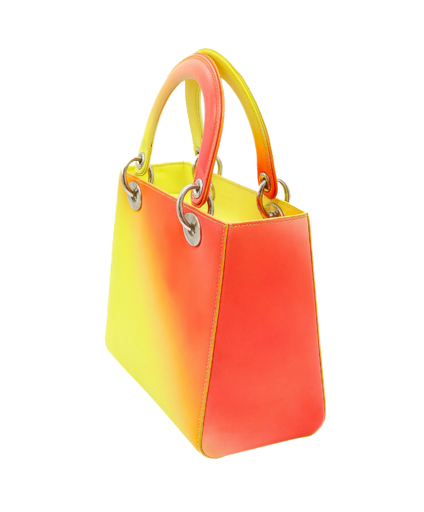Gradient yellow to Red Dior handbag with a visible brand logo on a white background