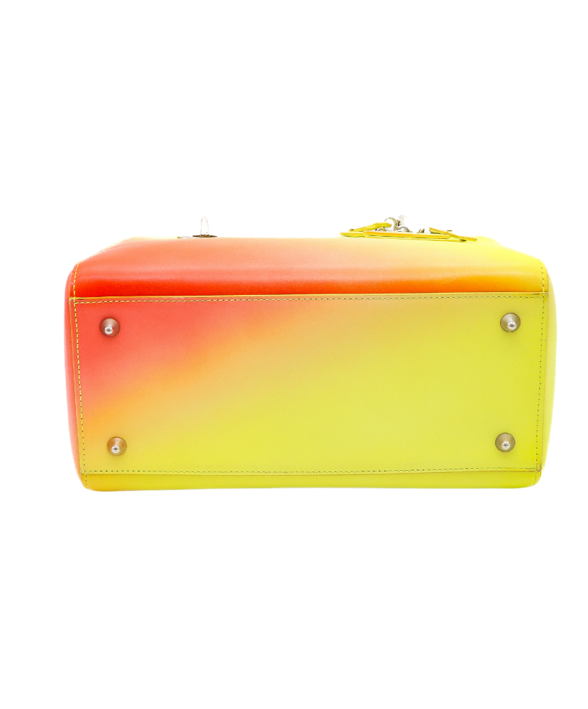 Gradient yellow to Red Dior handbag with a visible brand logo on a white background