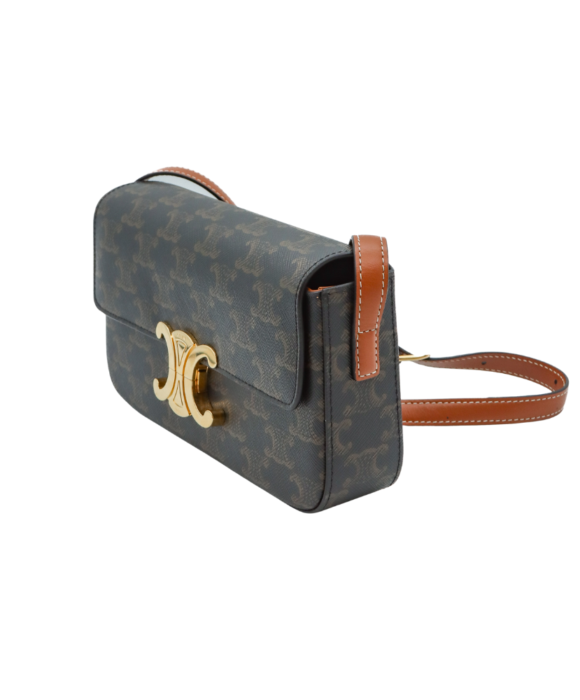 Celine Designer handbag with monogram pattern and gold clasp on a white background